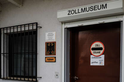 Vous pouvez voir l'entrée du musée des douanes avec une fenêtre à barreaux et une porte marron