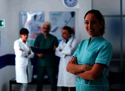 Pflegekraft im Vordergrund vor Ärzteteam