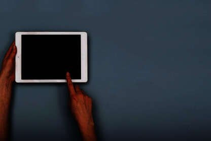 Tablet, das mit der linken Hand gehalten und mit der rechten Hand bedient wird